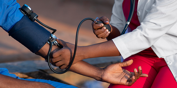 A health care work checks her patient's blood pressure. Photo courtesy Freepik.