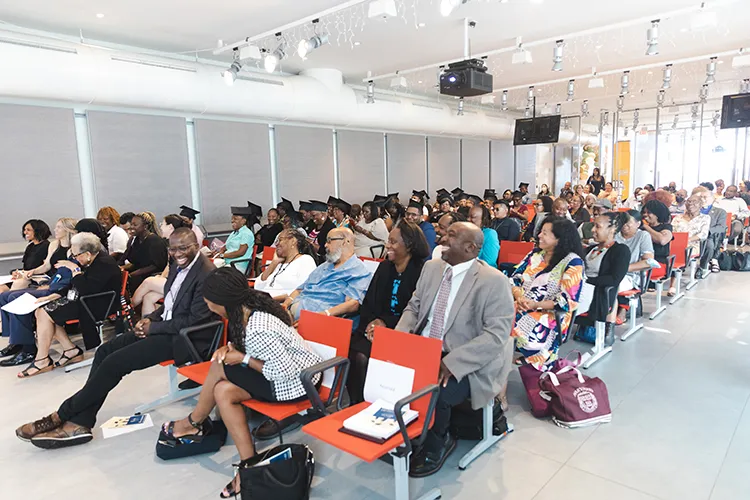 Room filled with seated guests attending the Summer 2023 graduation ceremony