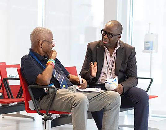Drs. Williams and Olajide are seated in discussion 