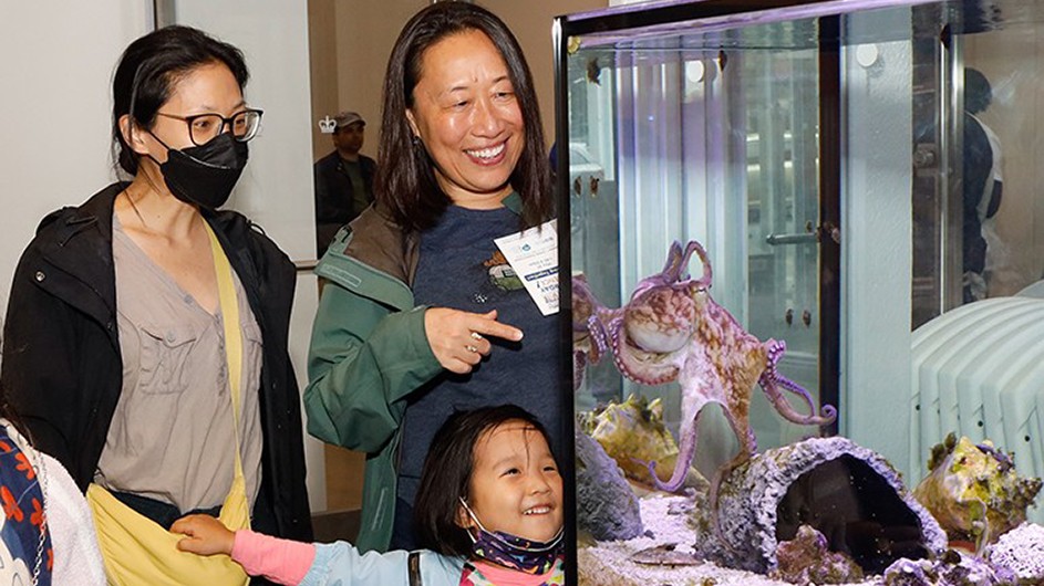 Two women and a young girl watch an octopus inside a tank at Saturday Science sessions at the Zuckerman Institute’s Education Lab. Photo credit: April Renae