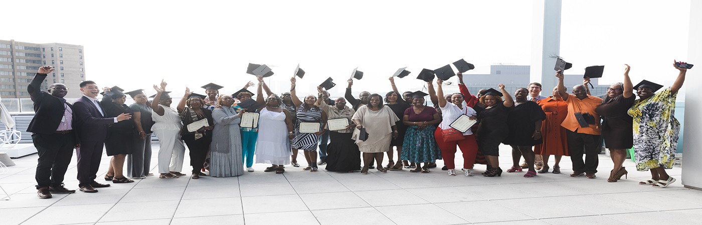 Program graduates gather side by side to take a photo 